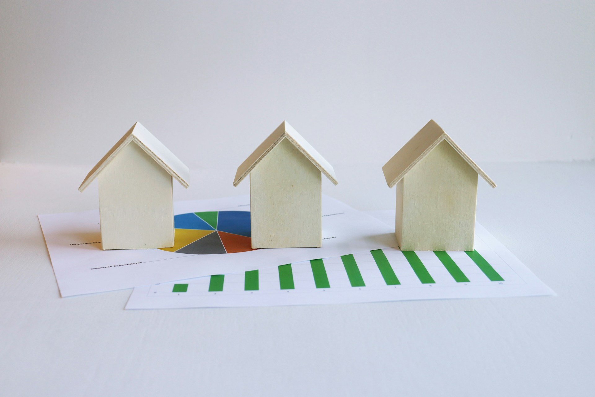 three wooden houses with data based diagrams