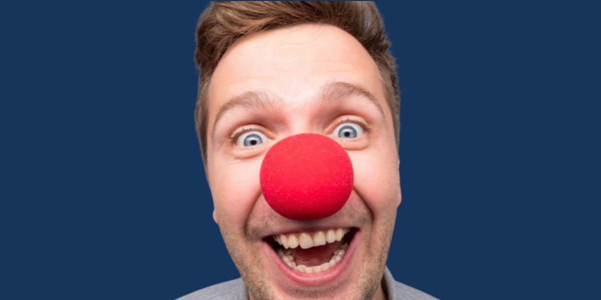 Man smiling wearing red nose for comic relief.