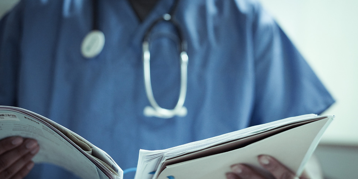Nurse wearing a stethoscope holding a patient chart.