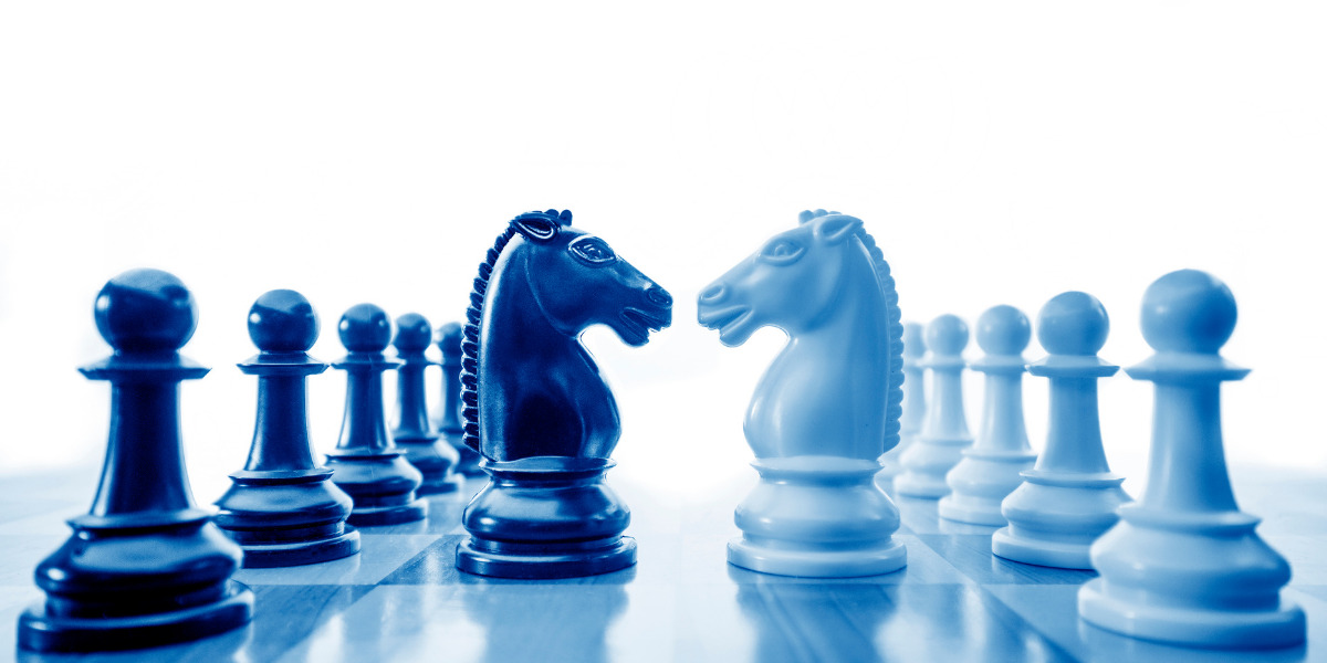 Chess board in two blue colours with knights facing eachother.