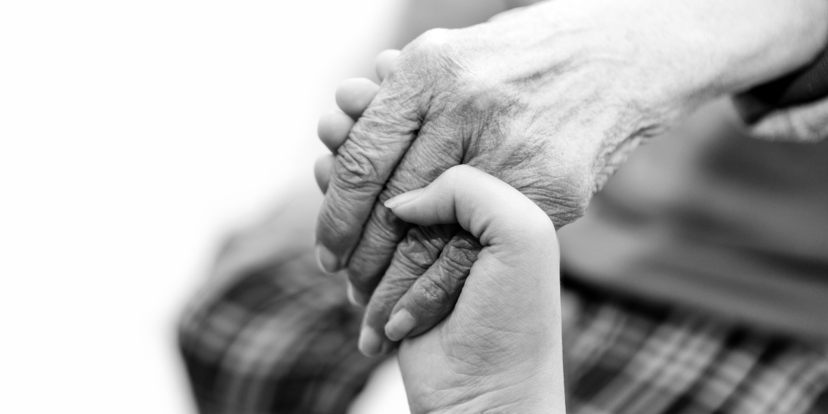 A young hand holding an old one.