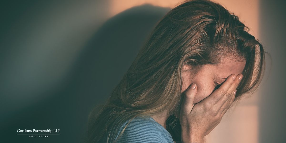 Woman crying with hands over her face