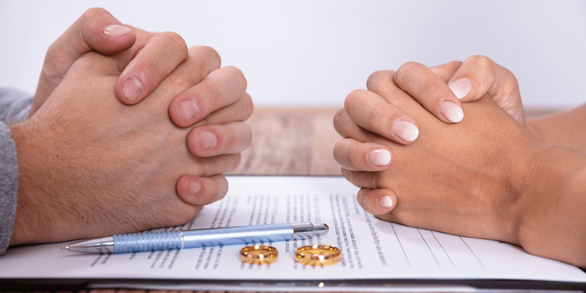 Couple with a document and wedding rings on the table
