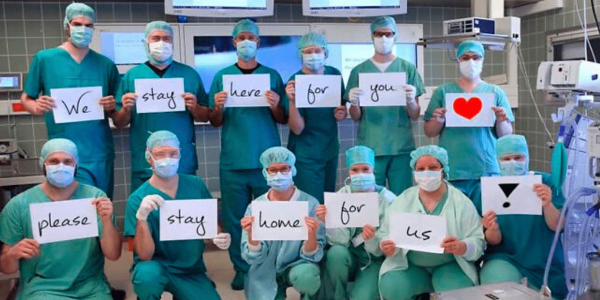 Doctors spelling out "We stay here for you, please stay at home for us"