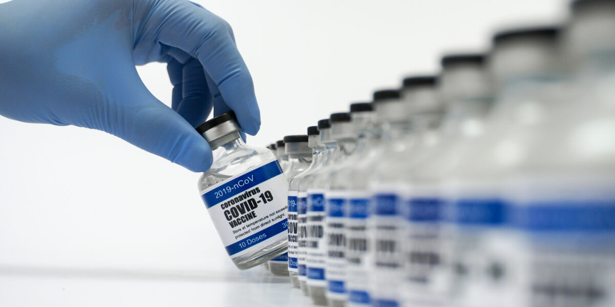 Row of covid 19 vaccines with one being picked up