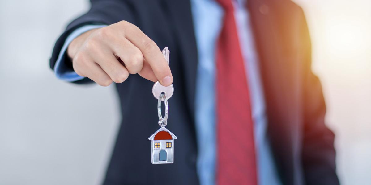 Man holding a key with a house symbol attatched