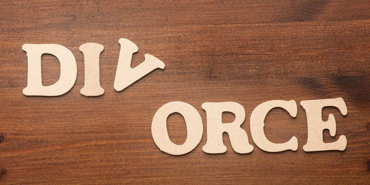 Letters cut out to spell divorce on wood table
