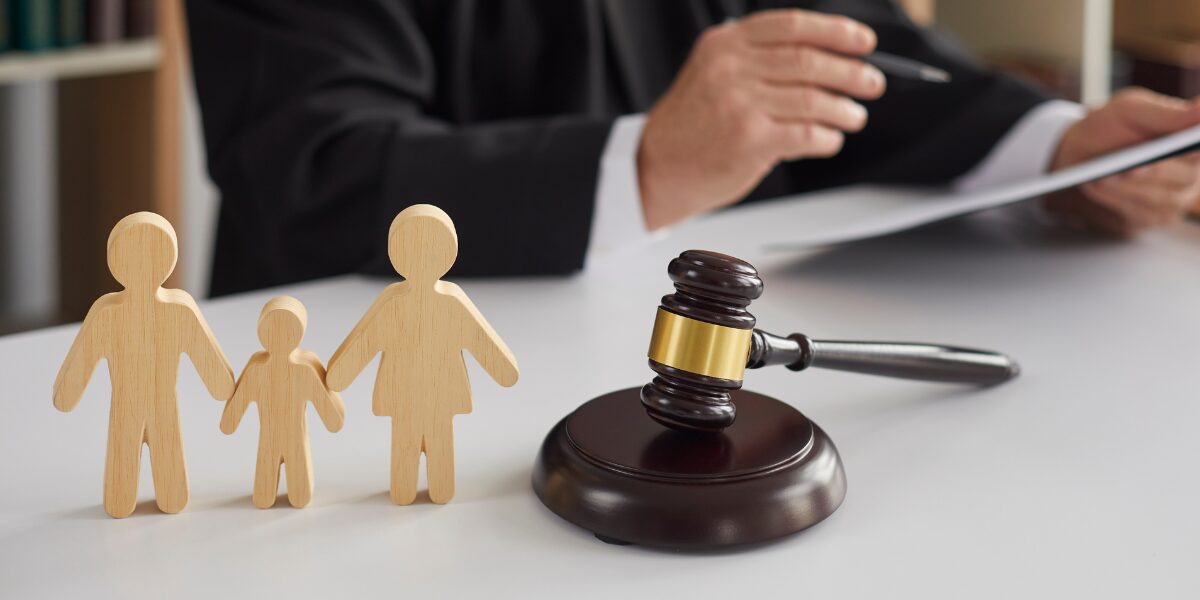 Wooden family figurines and a judge's gavel symbolize family law, highlighting the court fee increase in 2024.