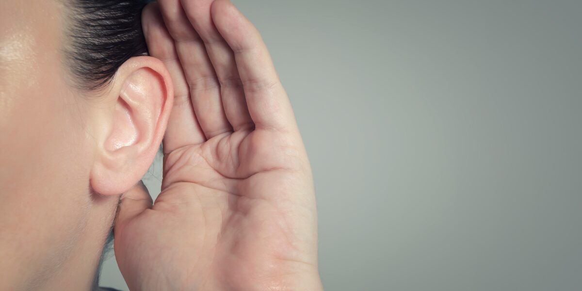A woman gestures with her hand to her ear, representing the Ofsted initiative "The Big Listen."